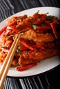 Schezwan chickenÃÂ orÃÂ szechuan chickenÃÂ is a popular appetizer from the Chinese cuisine close-up on a plate. vertical